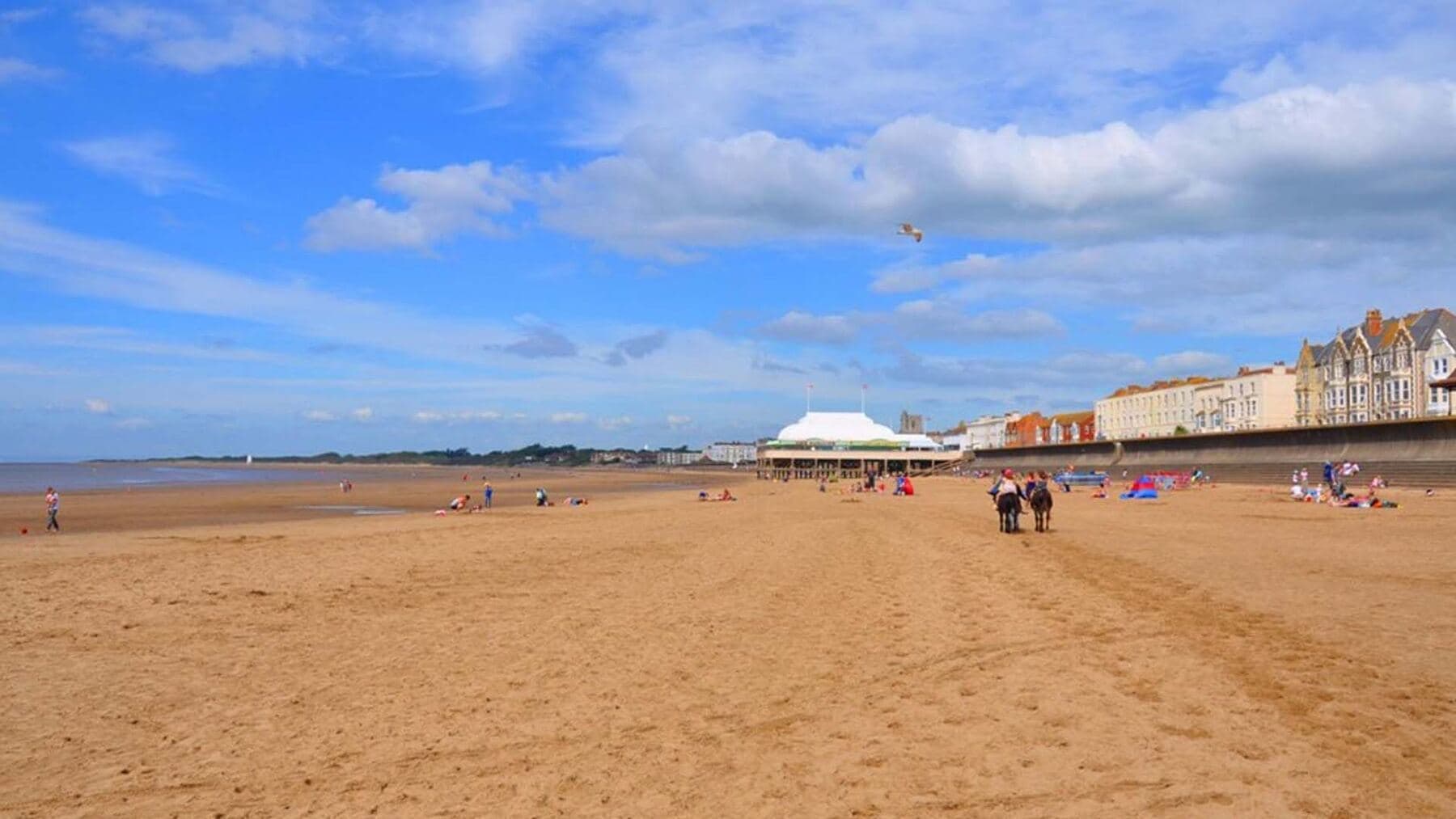 A wide sandy beach under a blue sky, a short walk from the festival pitches
