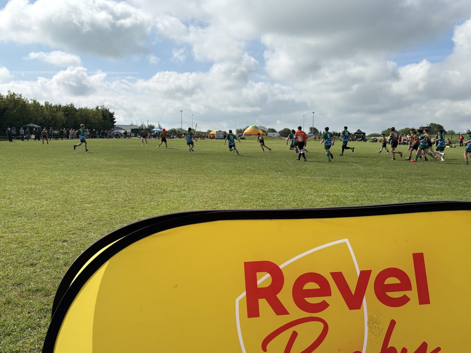Festival match action behind the Revel Rugby banner