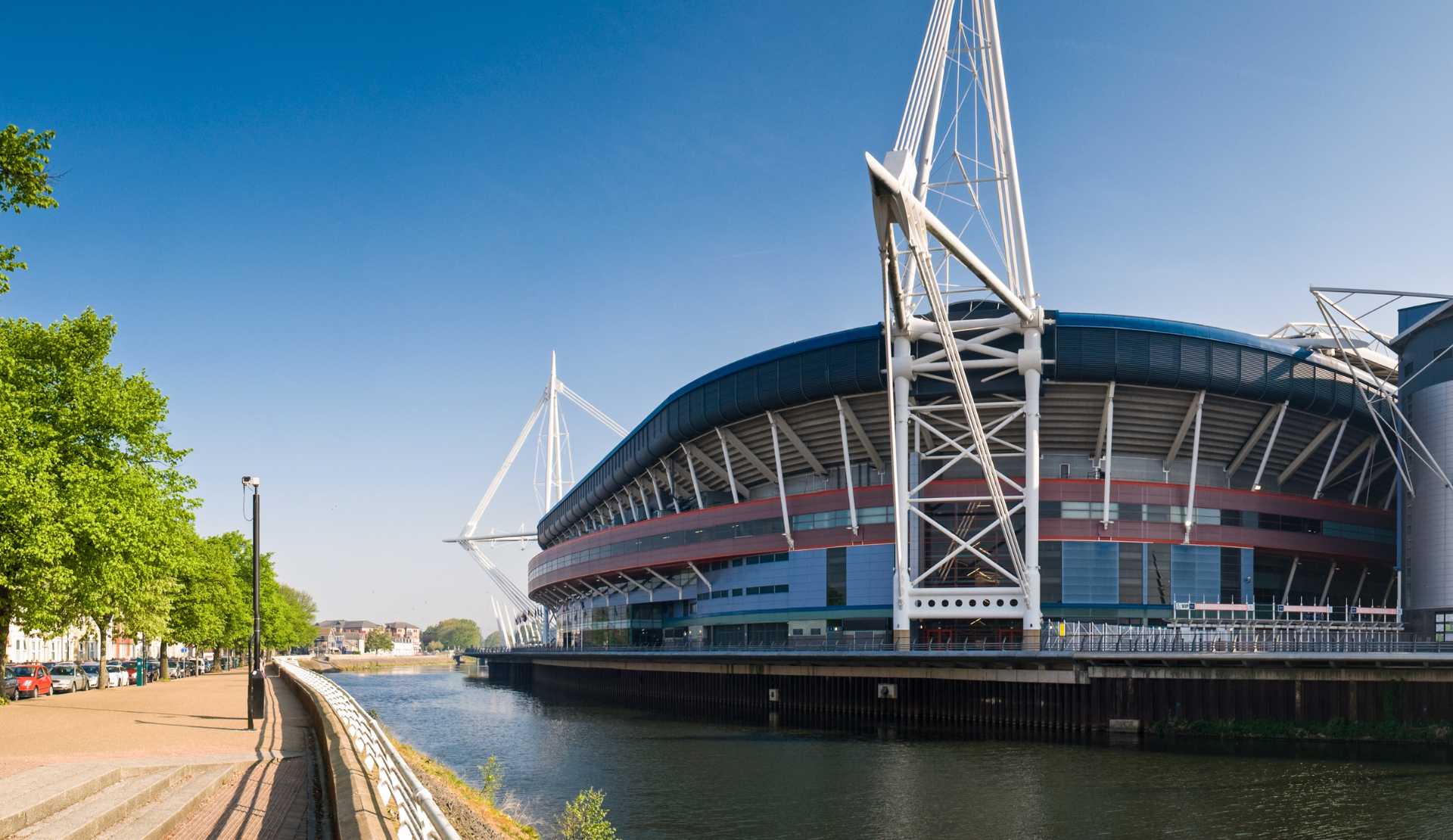 The Principality Stadium beside the River Taff in Cardiff under a clear blue sky