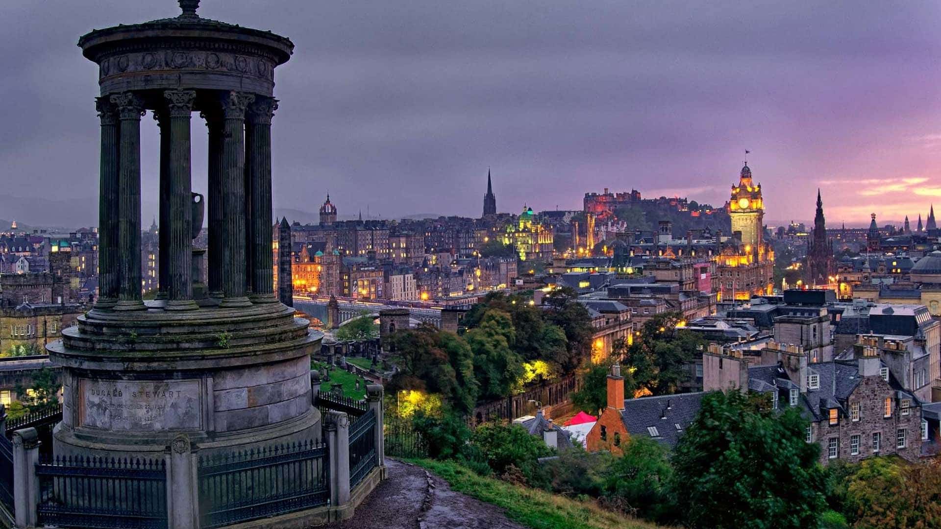 Edinburgh's old town and castle lit up at dusk, seen from Calton Hill